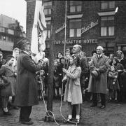 A flag being raised on Market Street, Tyldesley, during War Savings Week in 1943                                  Picture: Wigan and Leigh Archives and Local Studies