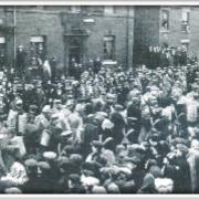 Crowds line King Street in Leigh town centre in 1915 as captured German prisoners of war are escorted towards the canal bridge heading for a camp at Lilford Weaving shed