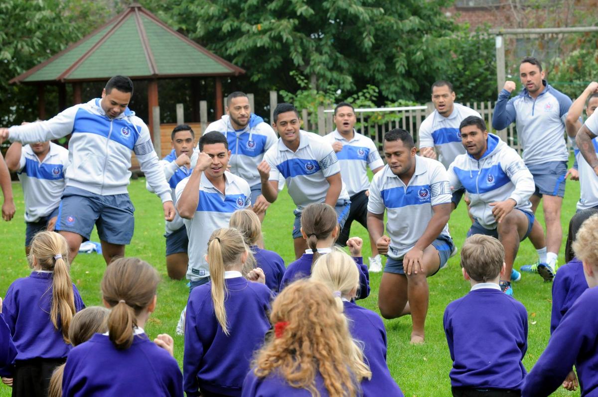 Samoan squad return the honour to Latchford Primary School pupils, performing the Siva Tau war dance that is similar to the New Zealand Haka