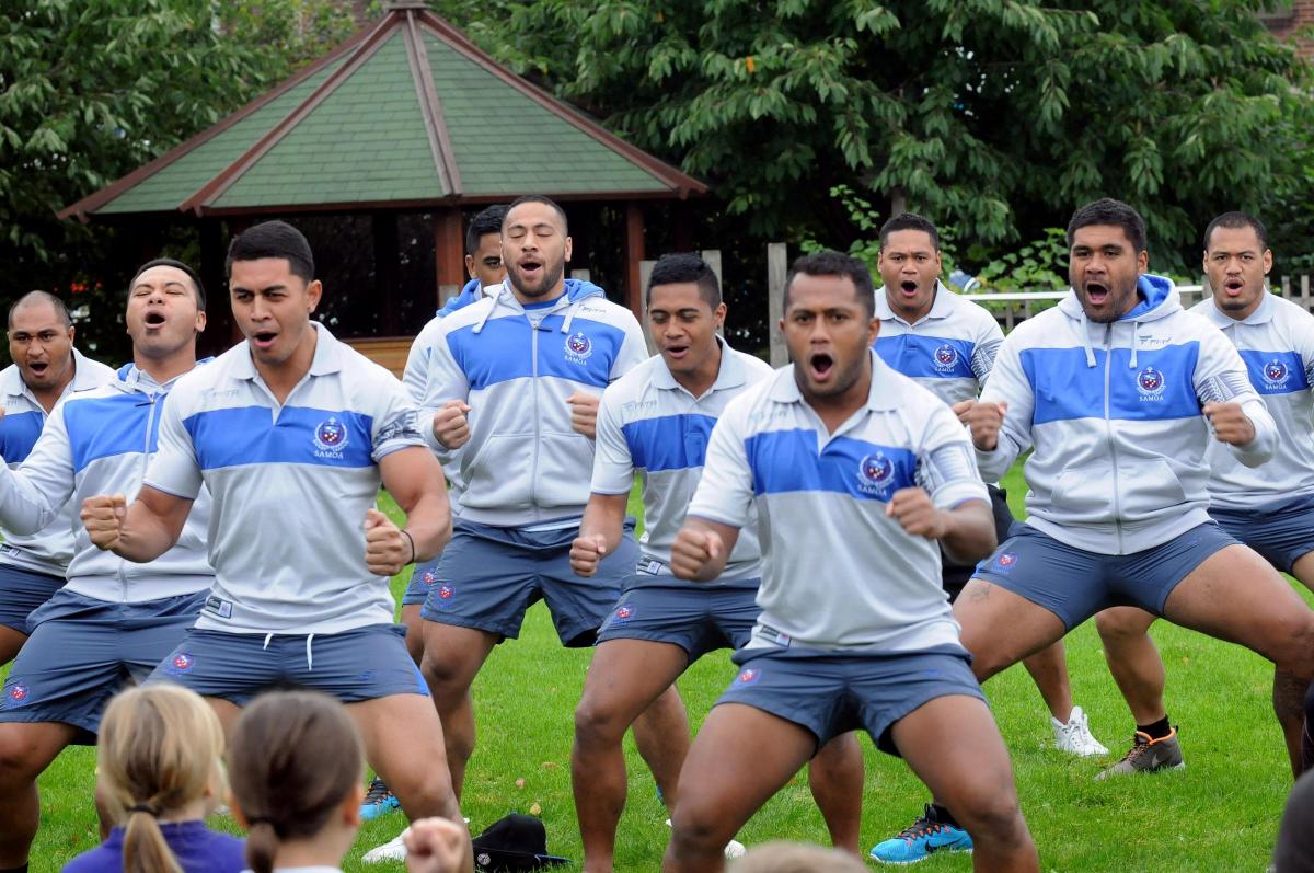 Samoan squad return the honour to Latchford Primary School pupils, performing the Siva Tau war dance that is similar to the New Zealand Haka