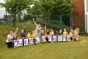 Children and staff at Hindley Nursery School celebrating their second 'Outstanding' Ofsted score in a row