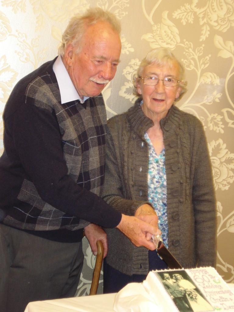 Margaret and Derek Lythgoe cutting the cake at their 60th wedding anniversary 