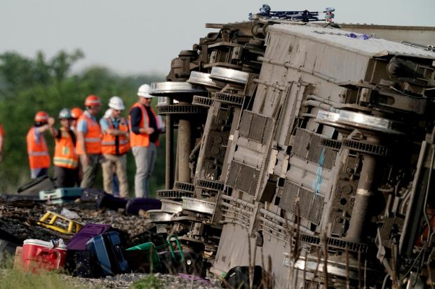 Workers at the scene where an Amtrak train was derailed after striking a lorry