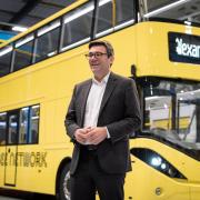 Greater Manchester mayor Andy Burnham next to one of the new Bee Network buses