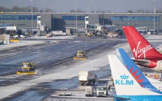 Snowploughs clearing the airfield at Manchester Airport after both runways were temporarily closed